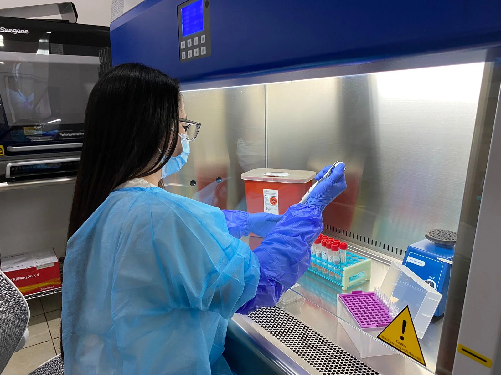 Doctora de BioMETRA Lab pipeteando muestras en cámara de flujo laminar